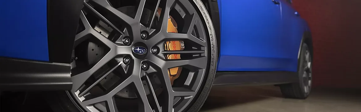 Close-up of a WRX alloy wheel and gold brake caliper