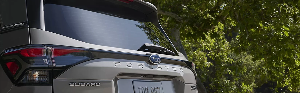 A close-up of the rear liftgate, taillight, and FORESTER badge of a silver Subaru Forester