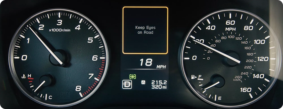 A Subaru instrument cluster showing a Keep Eyes on Road alert between the tachometer and speedometer