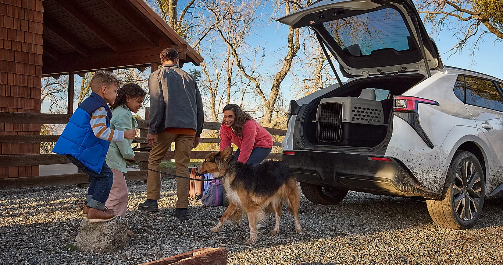 A family and dog loading gear into the open rear gate of a Solterra XT