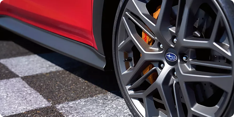 Close-up of a WRX tS alloy wheel and gold Brembo brake caliper