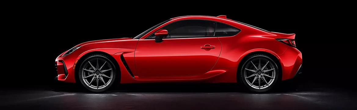 Profile of a red Subaru BRZ against a dark backdrop
