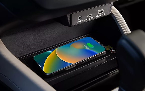 A smartphone charging on the wireless charging pad beside the USB ports of a Subaru Forester