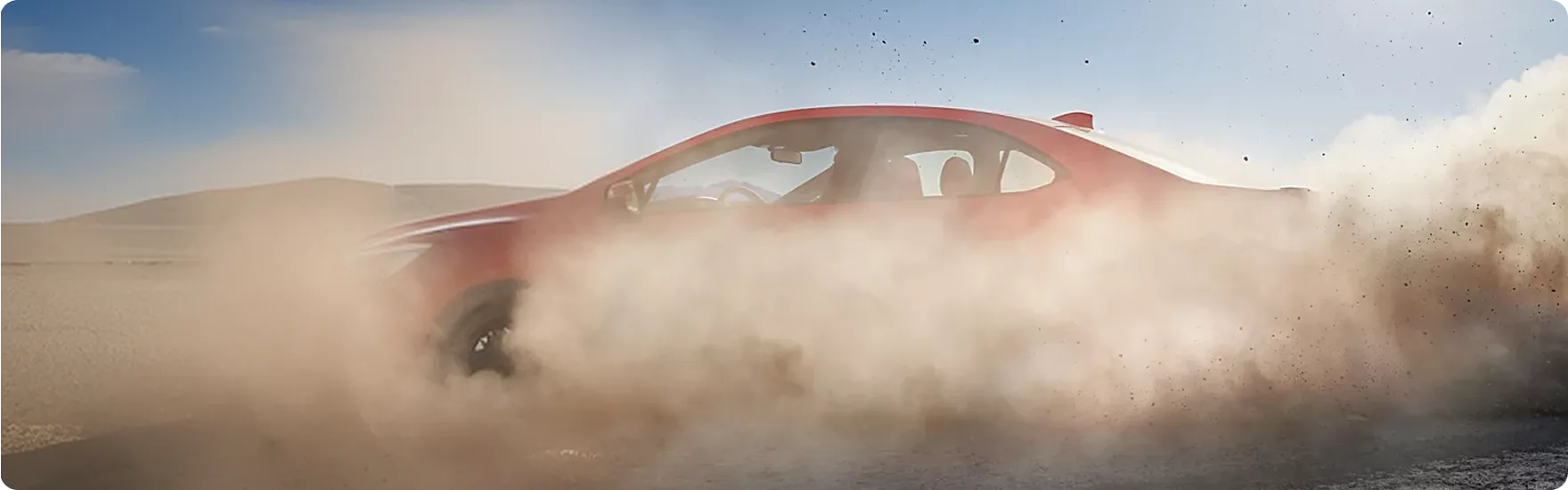 A Subaru WRX throwing up a plume of dust on a gravel road