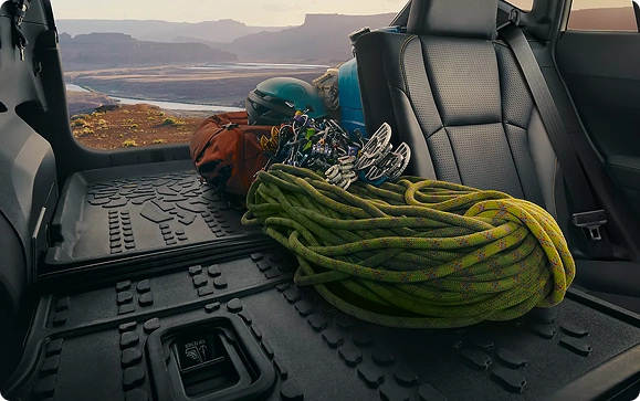 Climbing rope and gear loaded in the open cargo area of a Subaru Crosstrek at a canyon overlook