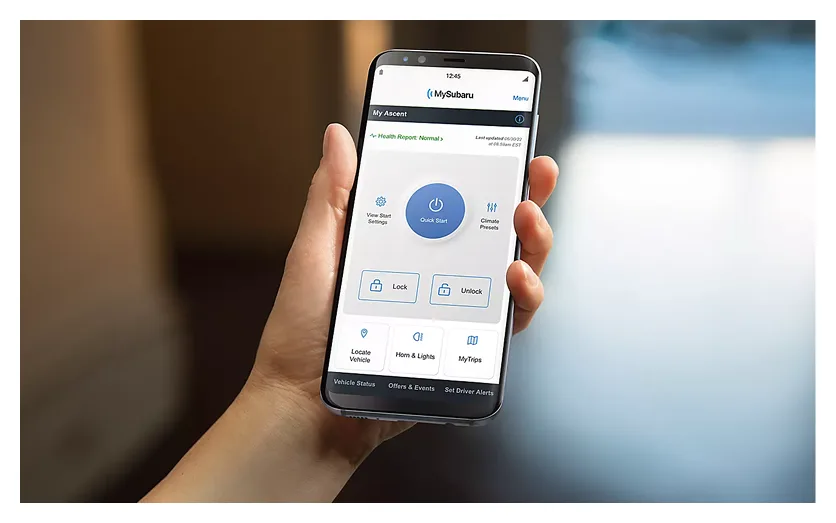 A hand holding a smartphone showing the MySubaru app remote controls