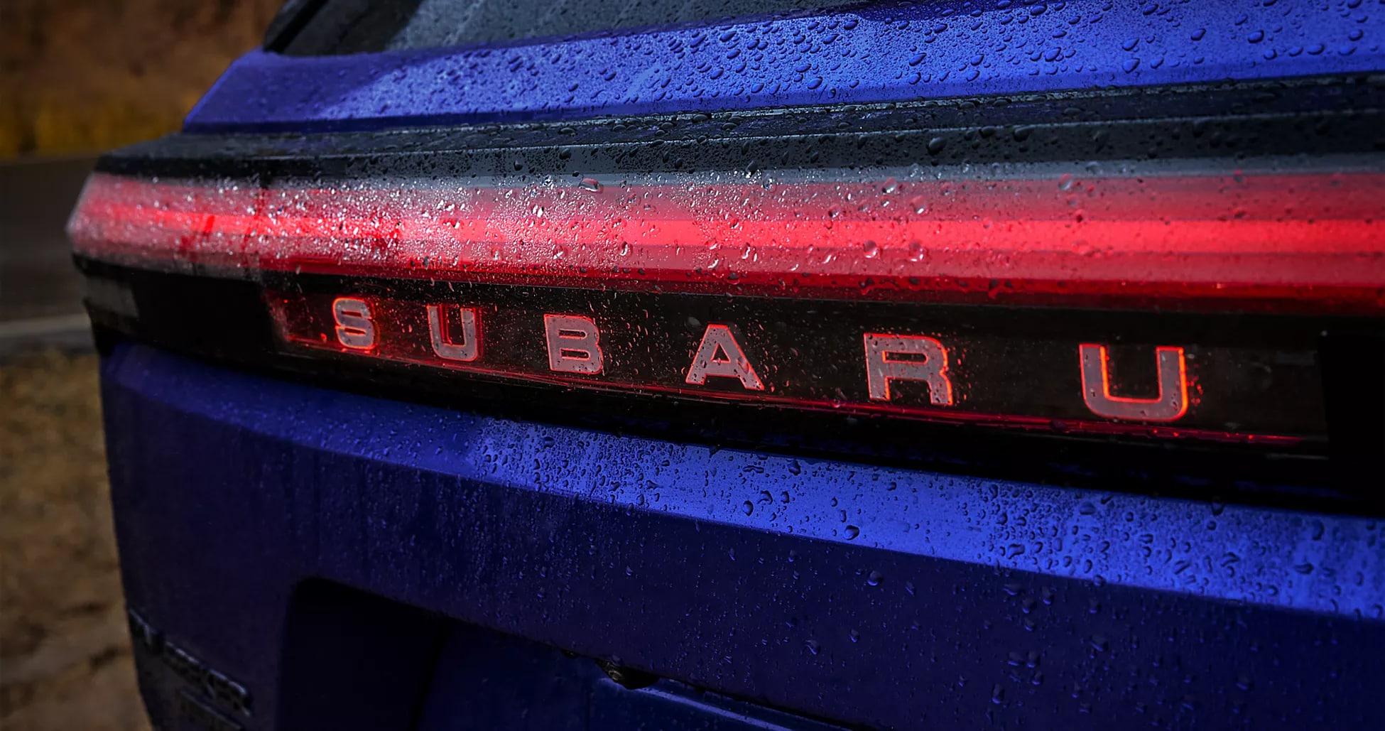 Close-up of the illuminated rear badge on a blue Trailseeker in the rain