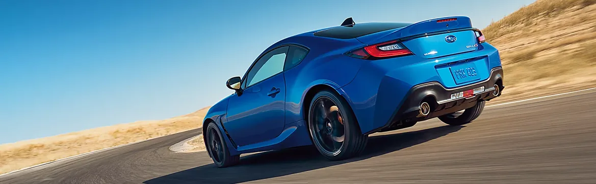 Rear three-quarter view of a blue Subaru BRZ on a desert road