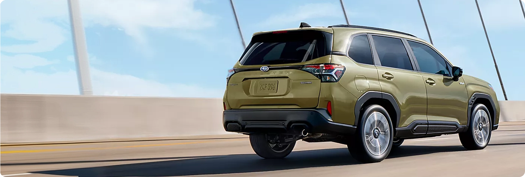 Rear three-quarter view of an olive-green Subaru Forester on a coastal road