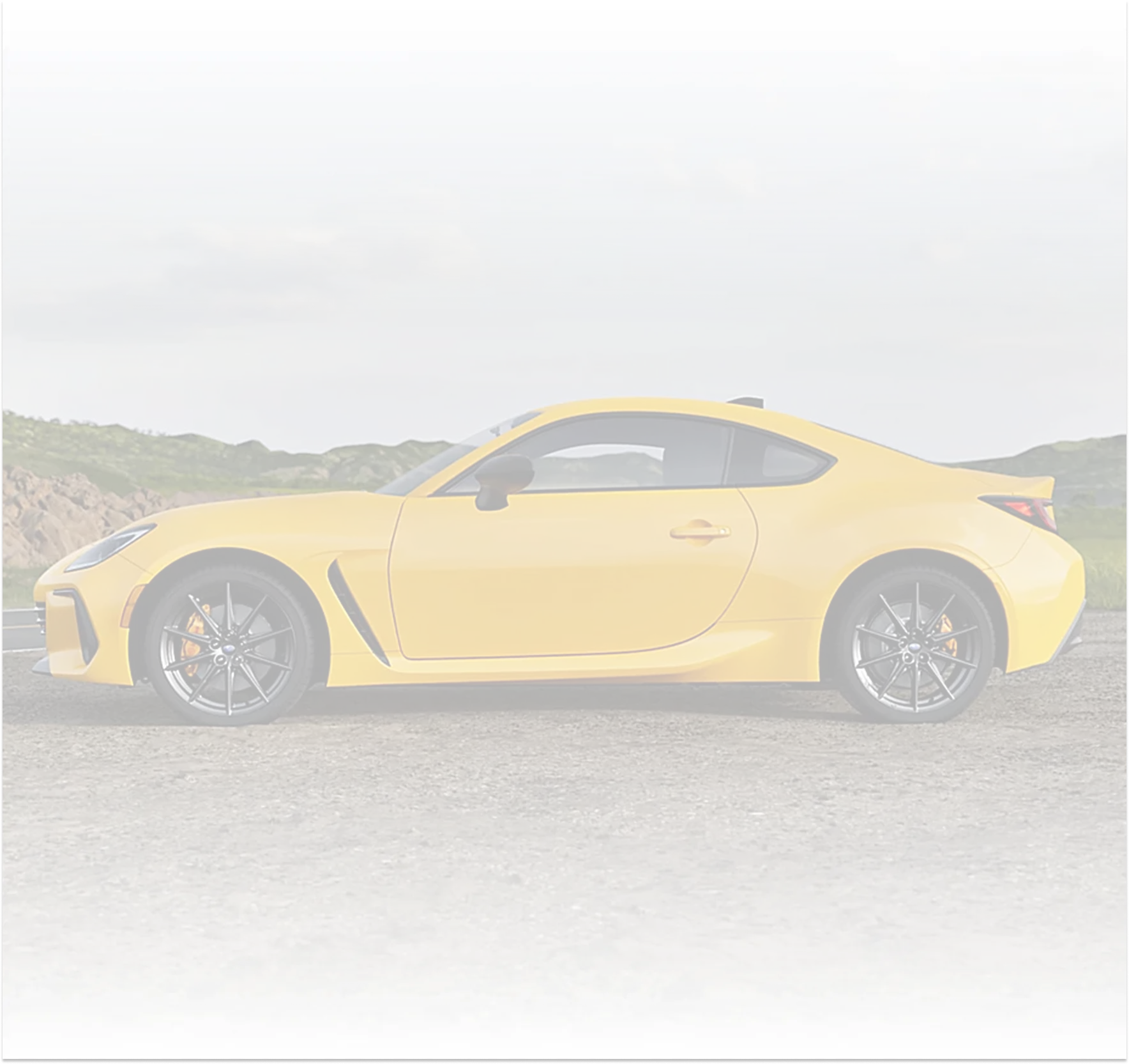 A yellow Subaru BRZ Series.Yellow on a green hillside road