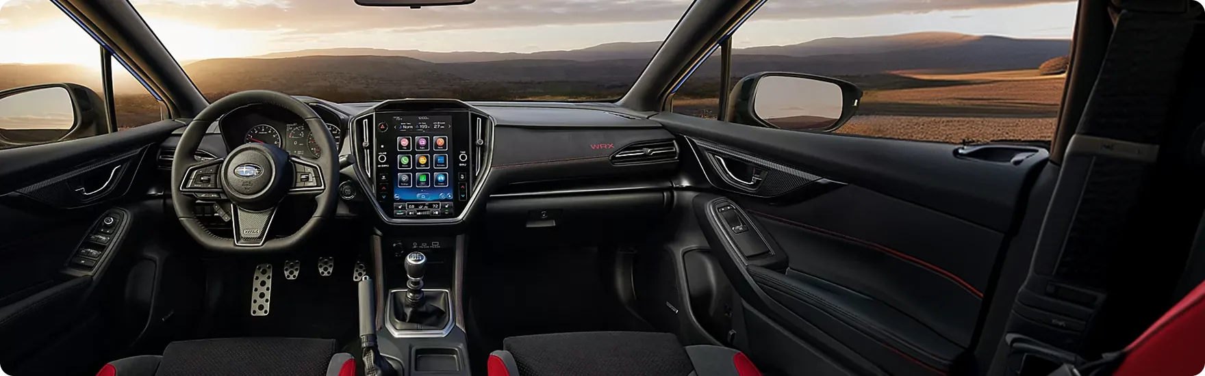 Driver’s view of the WRX cockpit with red-accented seats and open road ahead