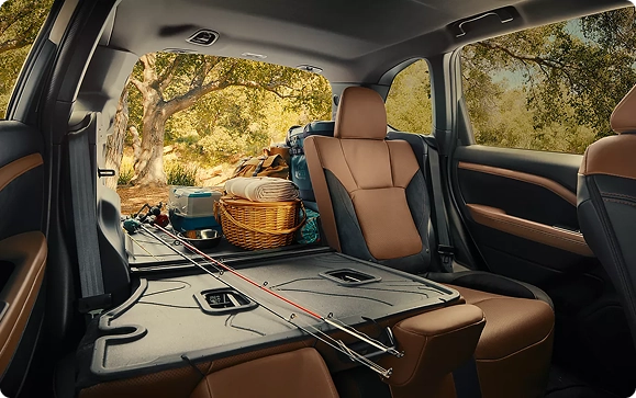The open cargo area of a Subaru Forester loaded with picnic gear, with the rear seats folded flat