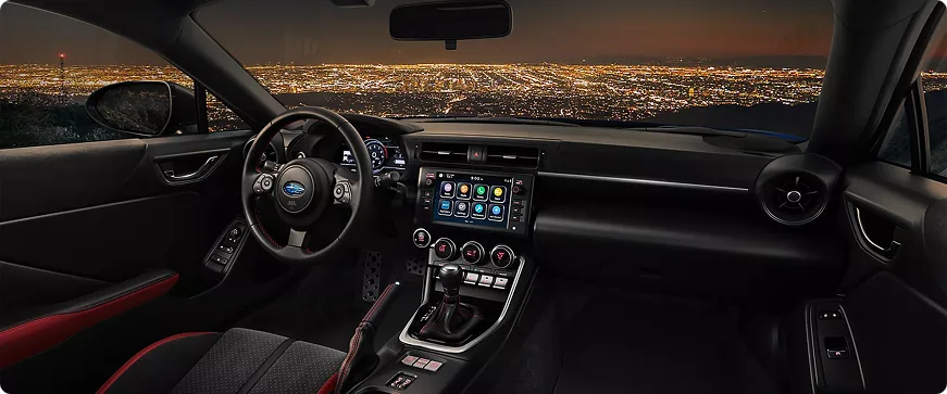 BRZ cockpit at night with city lights through the windshield