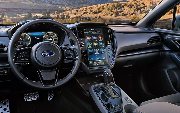 The steering wheel, digital gauges, and vertical touchscreen of a Subaru Crosstrek interior