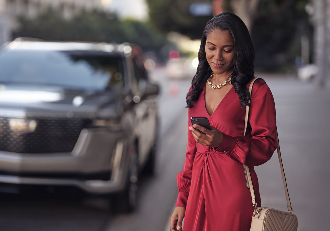  Woman scheduling service with a Cadillac in the background