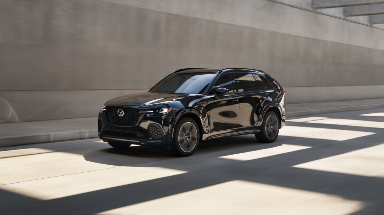 A black 2026 Mazda CX-70 driving through an urban tunnel.