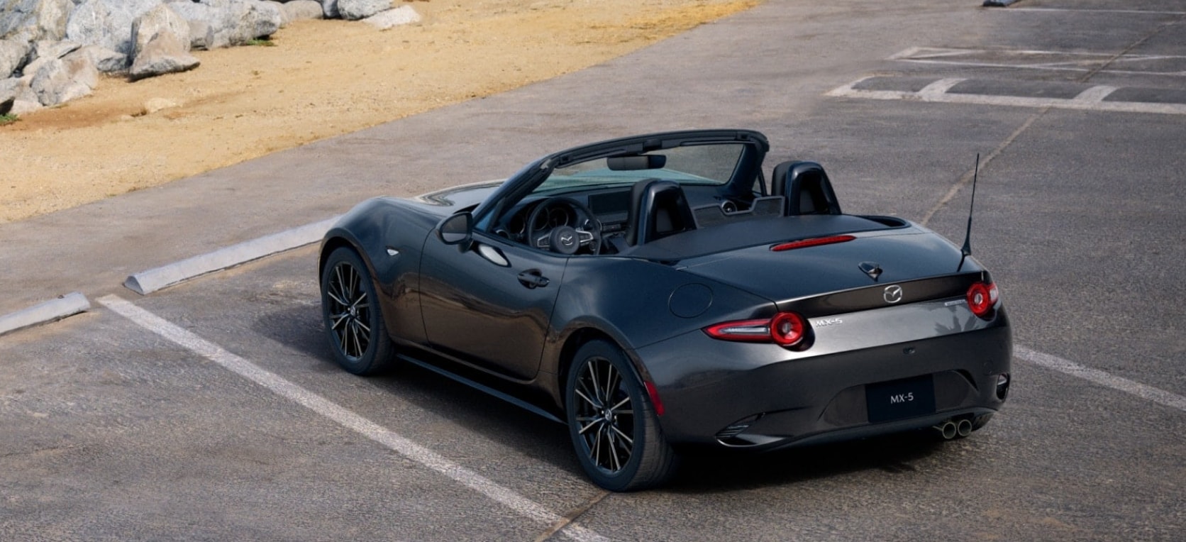 Grey 2026 MAZDA MX-5 Miata parked by beach.