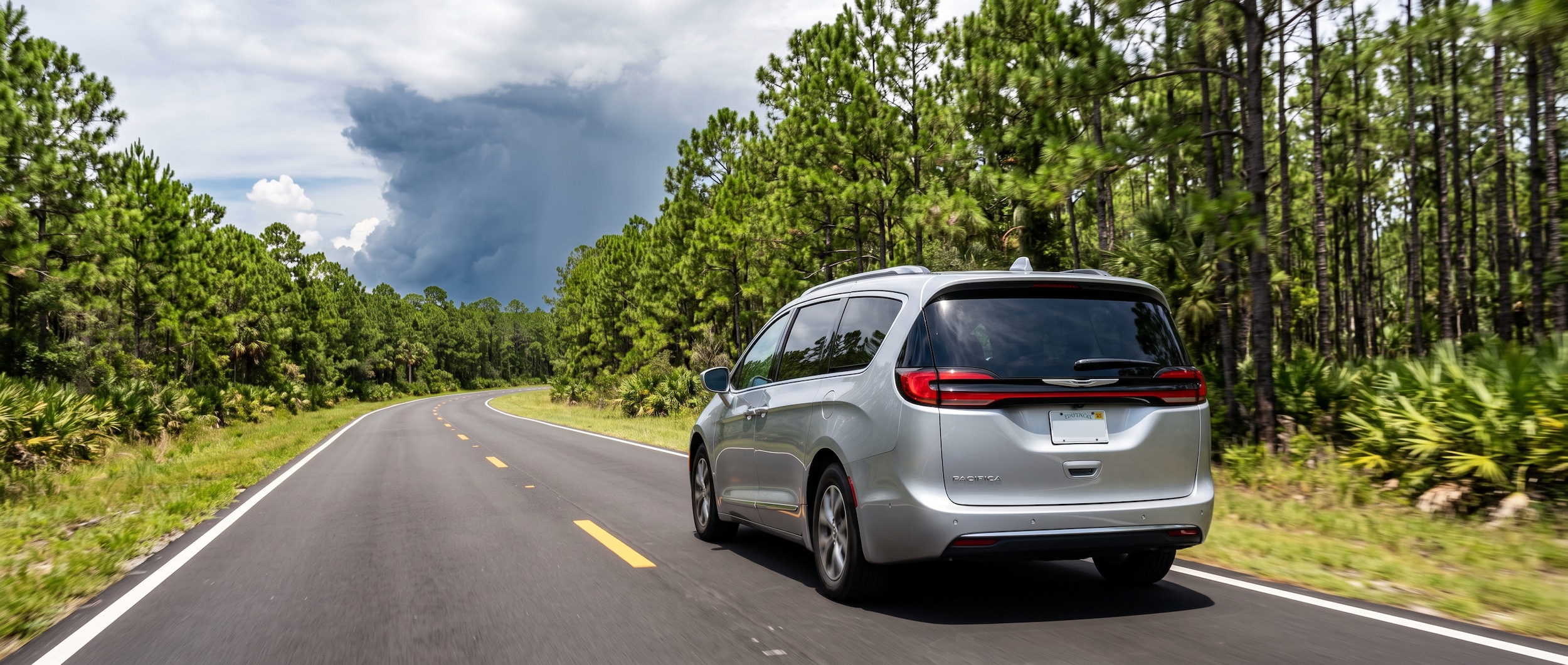 2026 Chrysler Pacifica on a Florida Panhandle highway with summer storm clouds in the distance