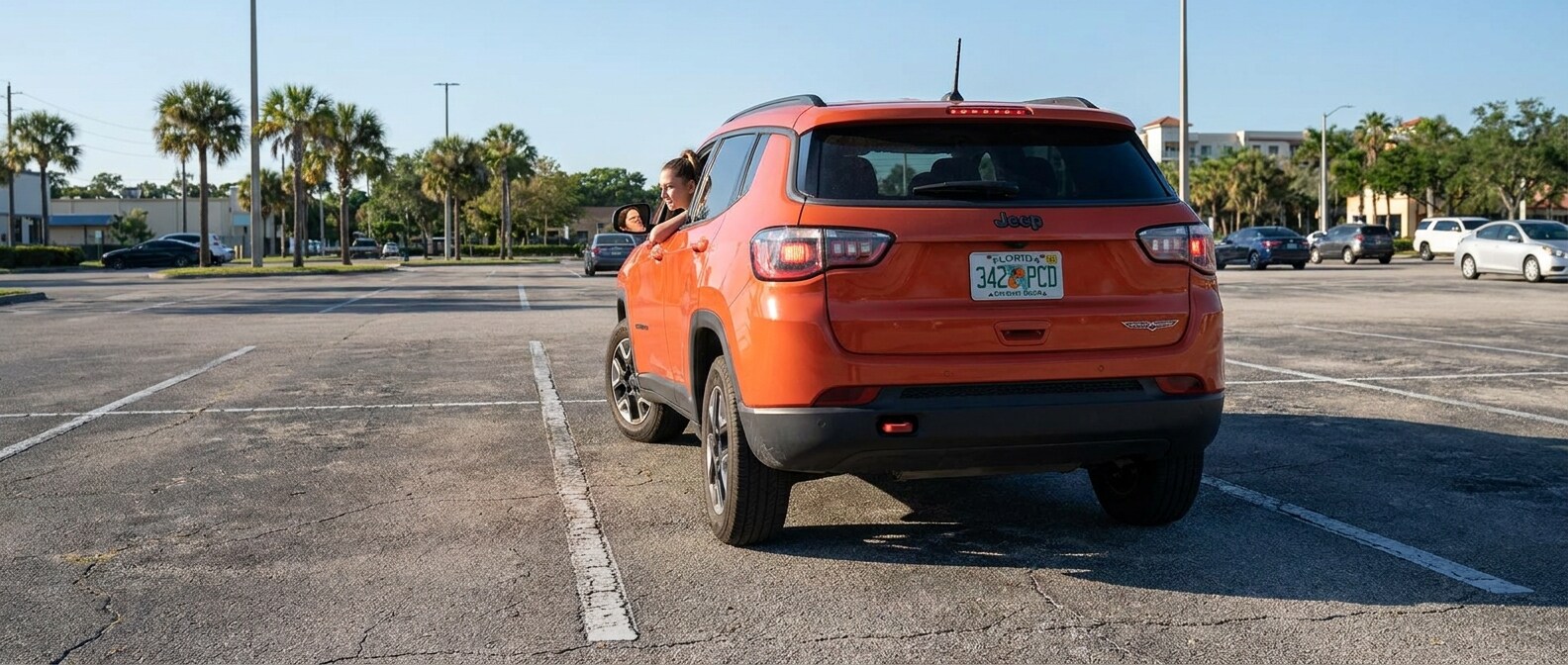 2026 Jeep Compass practicing reverse parking in a wide Panama City FL lot on a sunny summer day