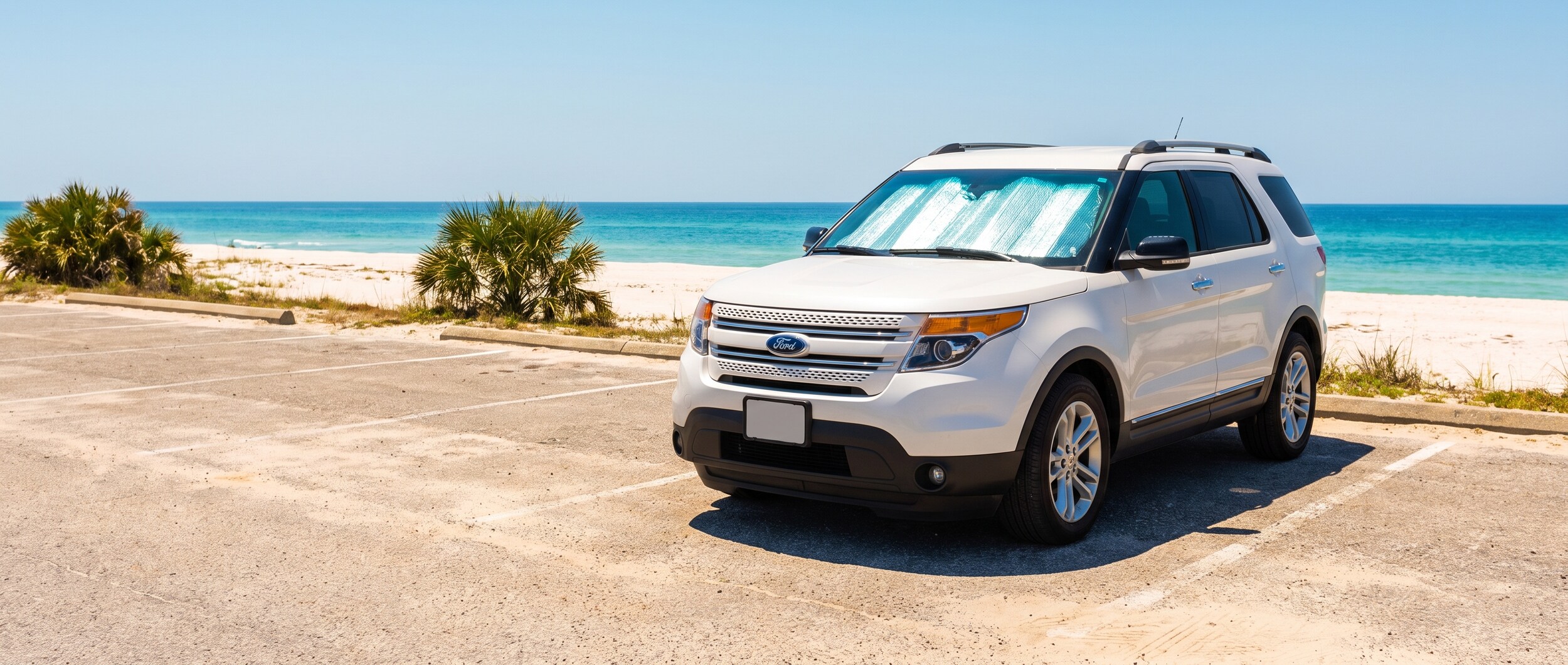 White SUV with windshield sunshade parked in open Panama City Beach parking lot on a sunny summer day