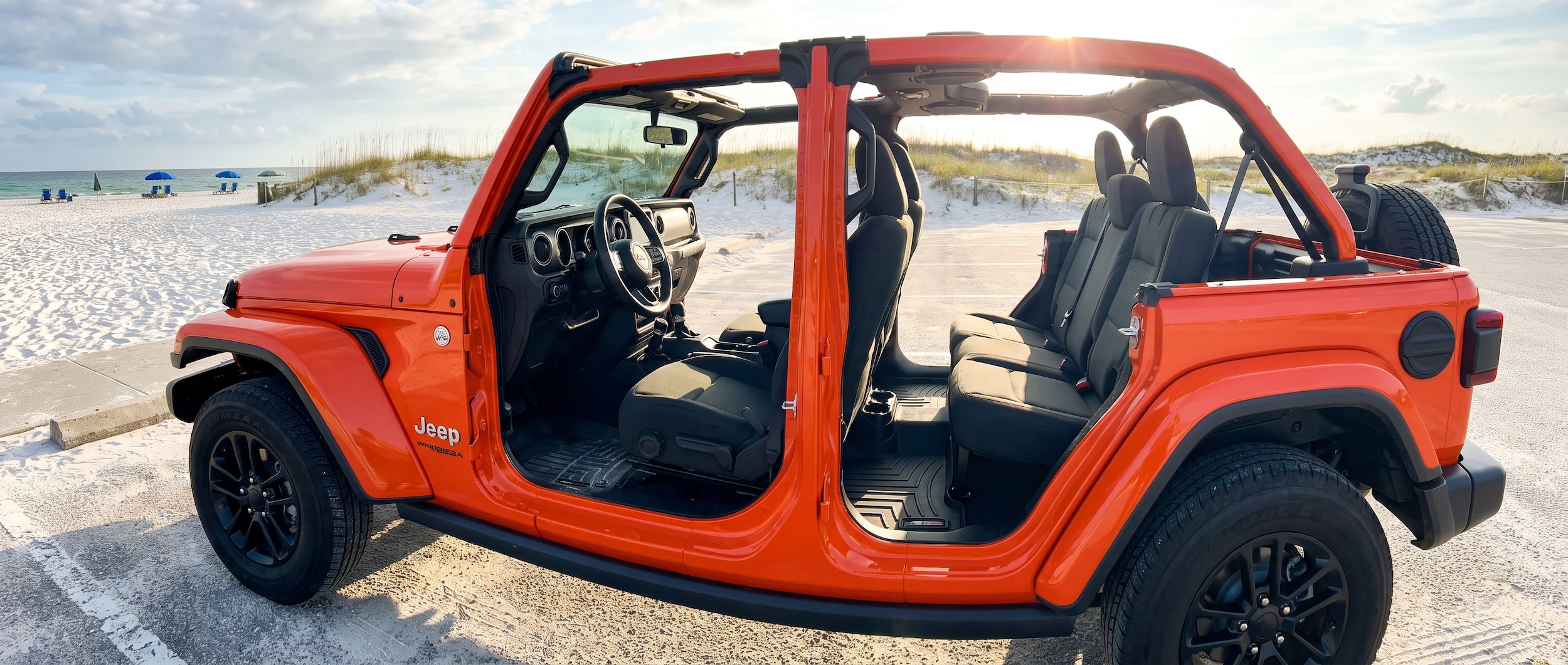 2026 Jeep Wrangler JL parked at Panama City Beach with doors off, black all-weather floor mats visible inside