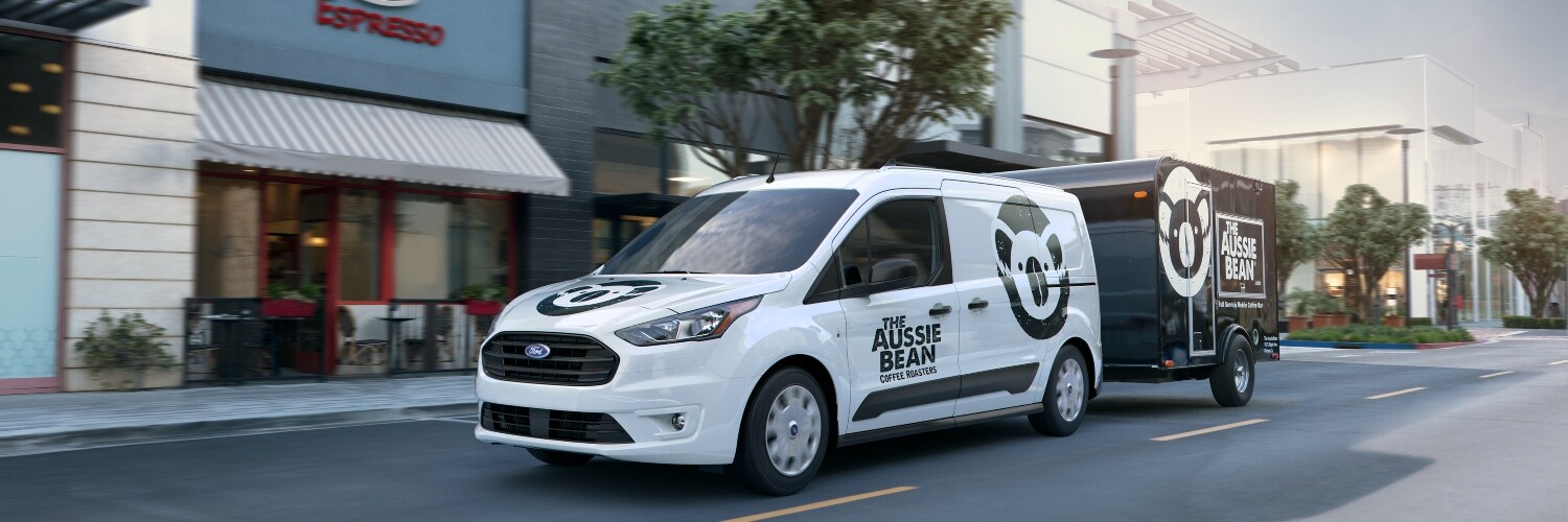 2023 Ford Transit driving down the road with trailer
