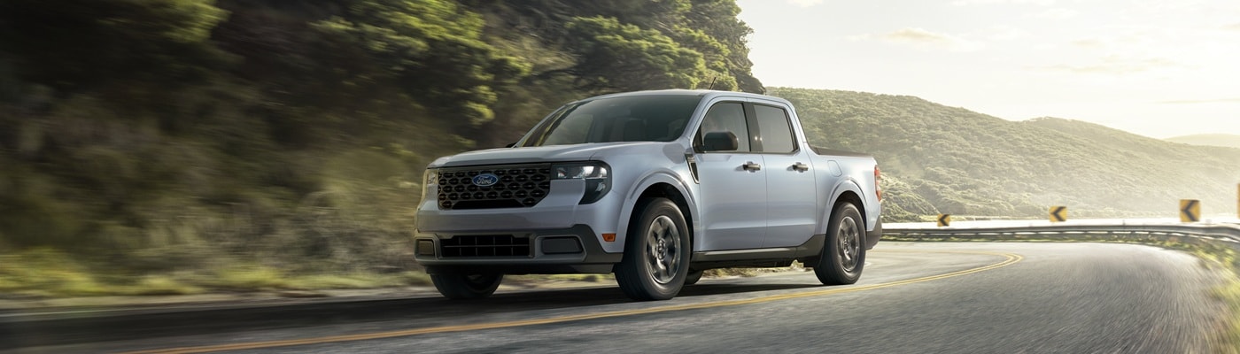 White Ford Maverick XLT driving on a coastal highway
