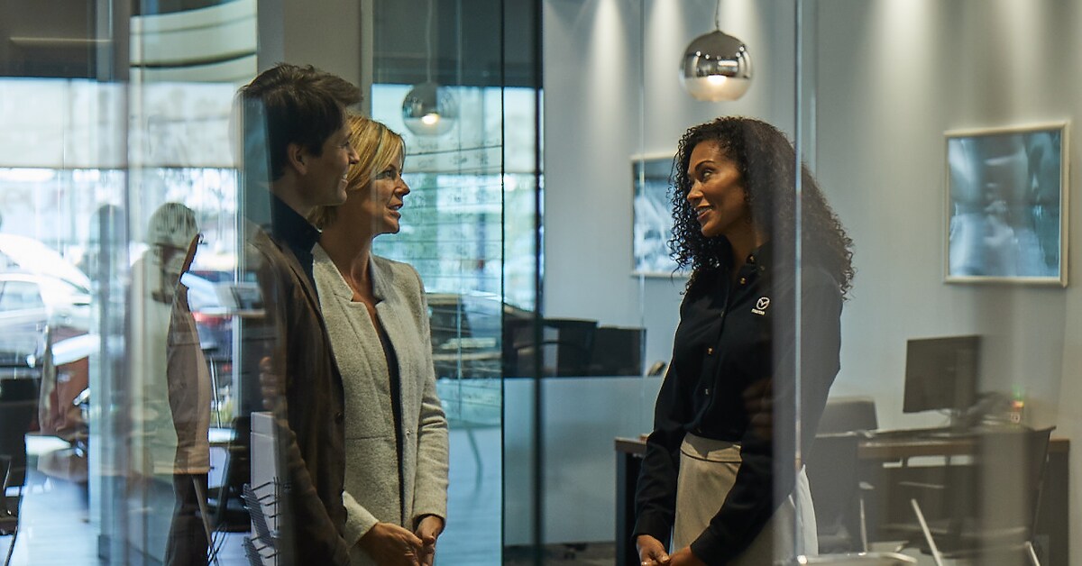 Mazda customer service with couple in Basney Mazda showroom.