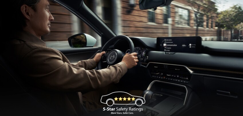  Driver inside the 2026 Mazda CX-90 PHEV interior with dashboard display.