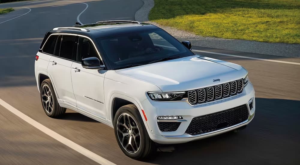 A white 2024 Jeep Grand Cherokee driving to a Jeep dealer near Pittsfield.