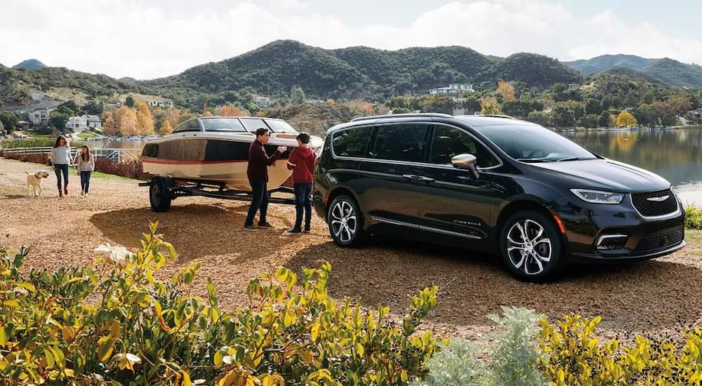 A black 2923 Chrysler Pacifica is shown fromt he side while hooked up to a boat trailer.