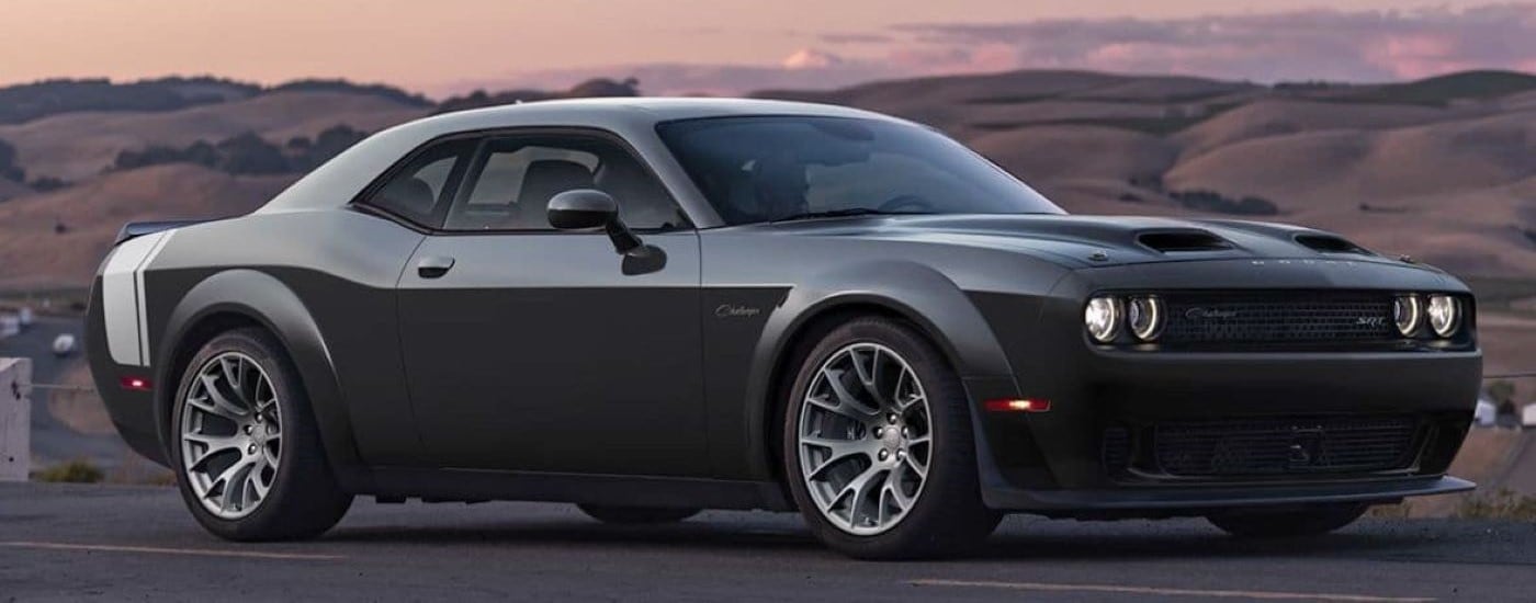 A black 2023 Dodge Challenger SRT driving from a Dodge dealer near Pittsfield.