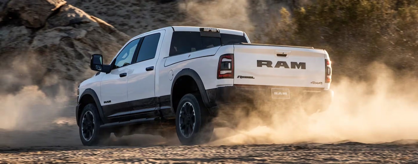 A white 2024 Ram 2500 Rebel is shown from the rear at an angle.