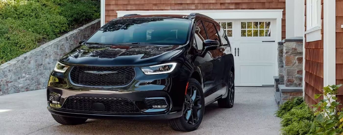 A black 2024 Chrysler Pacifica is shown parked on a driveway.