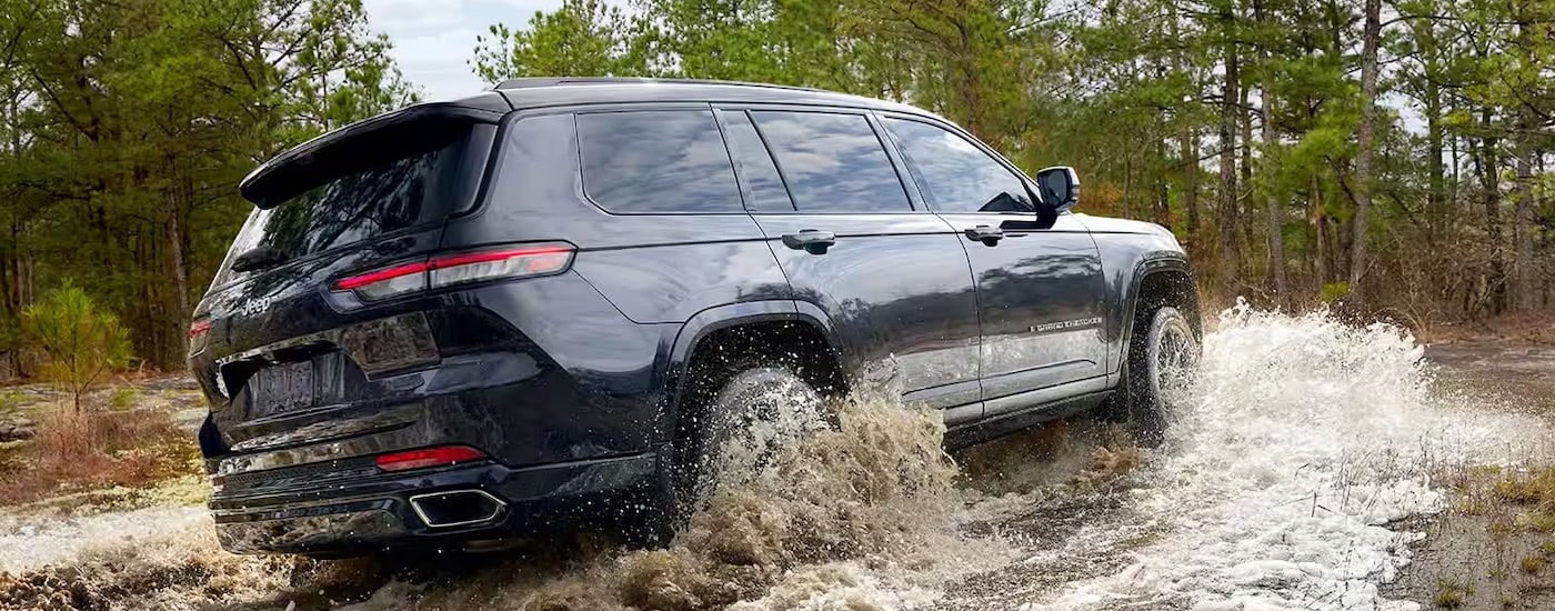 A blue 2022 Jeep Grand Cherokee is shown from the rear at an angle after leaving a Jeep dealer near North Adams.