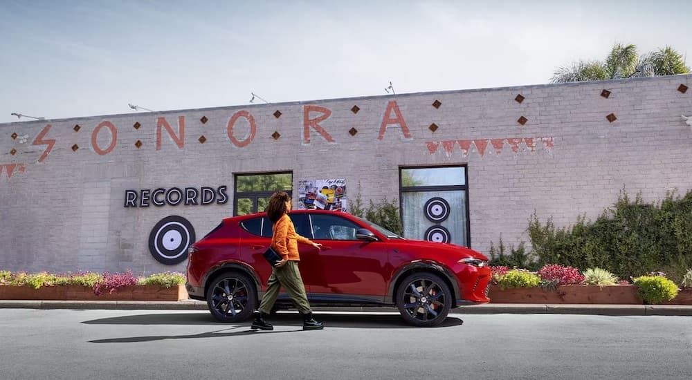 A red 2024 Dodge Hornet is shown from the side after leaving a Dodge dealer.