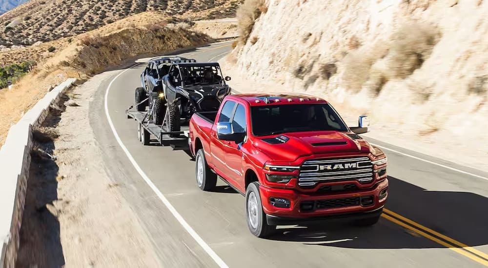 A red 2025 Ram 2500 for sale is shown towing a trailer.