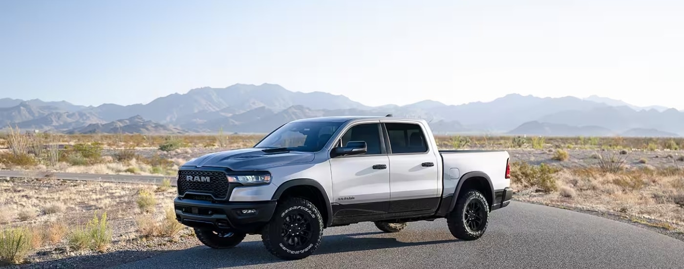 A white 2025 Ram 1500 for sale parked in an open prairie.