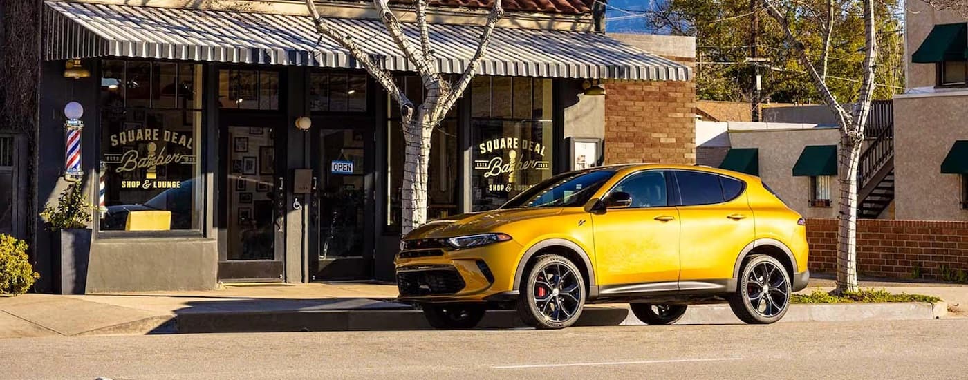A yellow 2024 Dodge Hornet GT is shown from the side on a city street.
