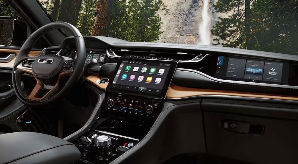 The black and brown interior and dash are shown in a 2025 Jeep Grand Cherokee.