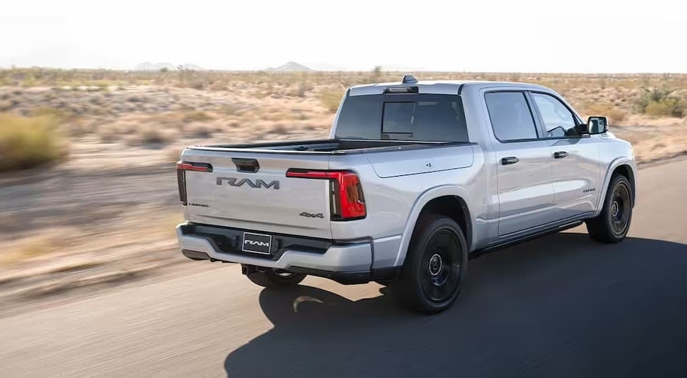 Rear view of a white 2025 Ram 1500 Ramcharger driving.