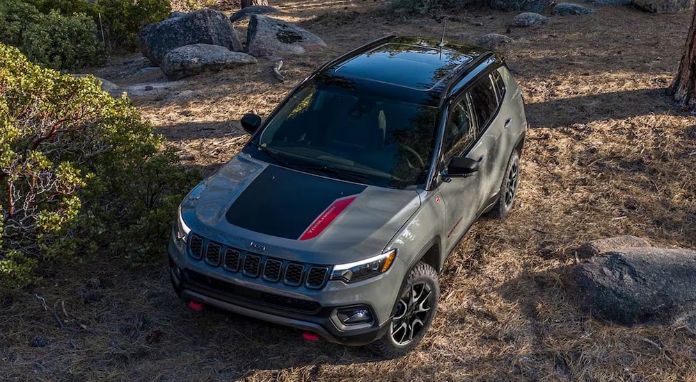 Overhead view of a grey 2024 Jeep Compass Trailhawk driving in the woods.