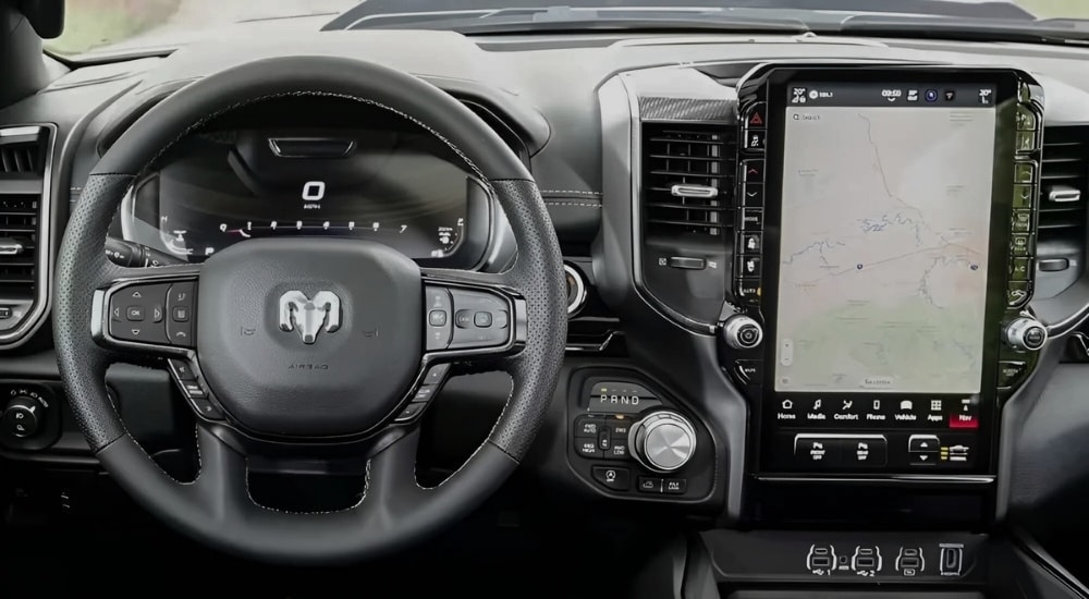 The steering wheel and infotainment screen in a 2024 Ram 1500 for sale.