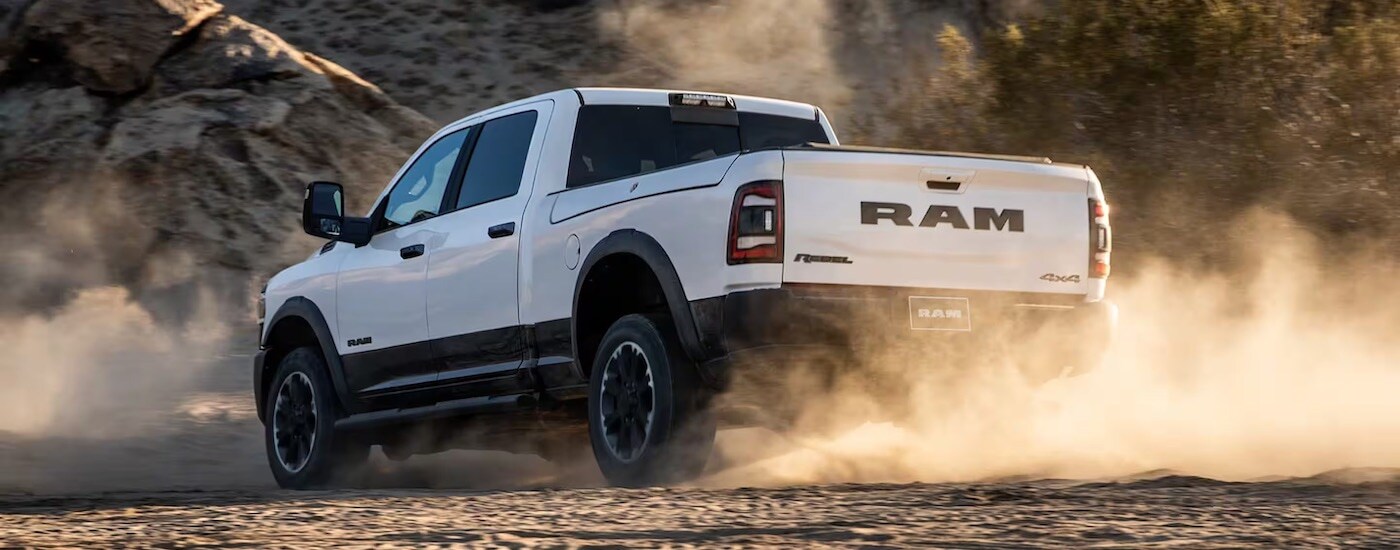 A white 2024 Ram 2500 Rebel is shown from the rear at an angle.