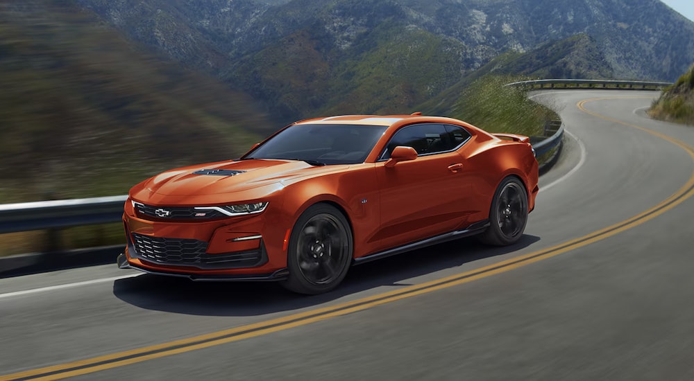 An orange 2024 Chevy Camaro 2SS driving on the highway.