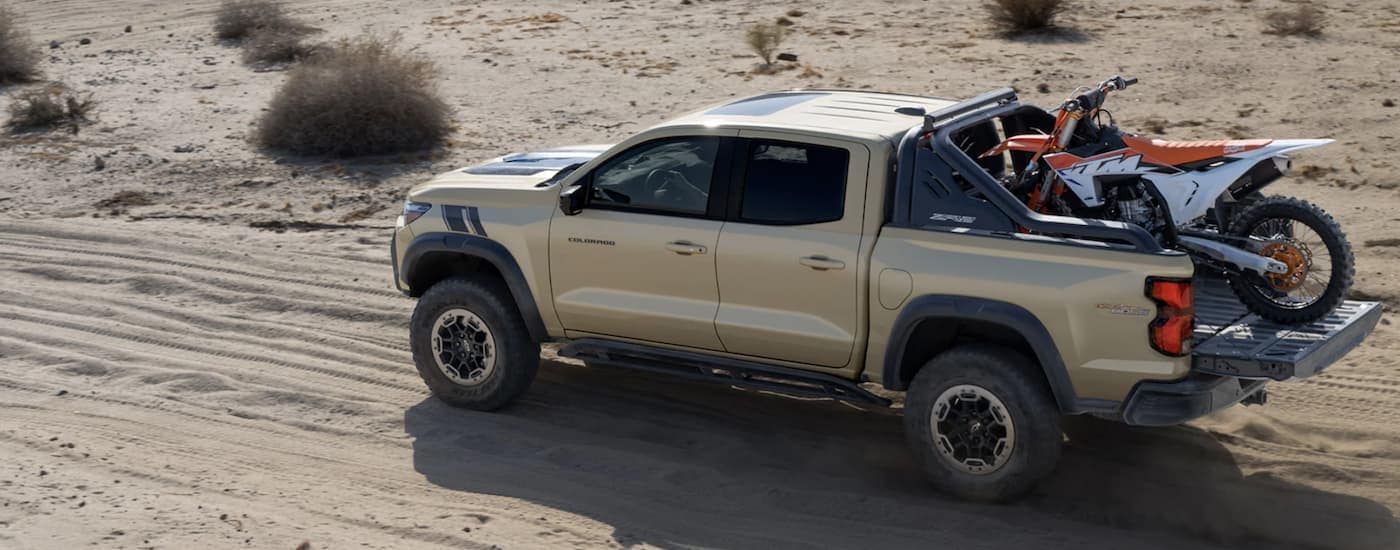 A tan 2024 Chevy Colorado ZR2 Desert Boss driving off-road.