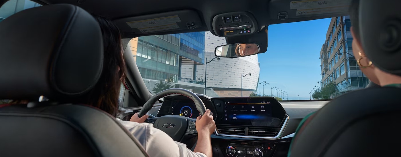 A woman driving in a 2025 Chevy Trax for sale.