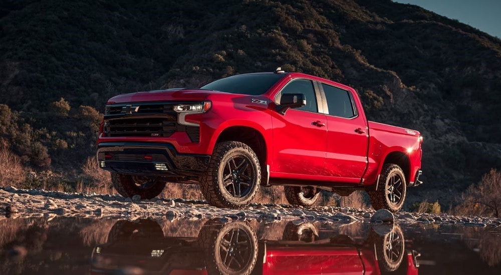 A red 2024 Chevy Silverado Z71 is shown from the side while off-road.