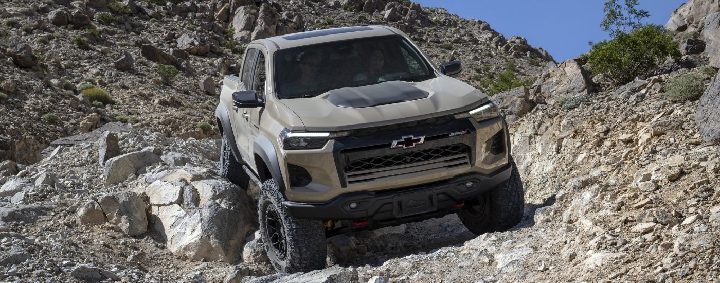 A silver 2024 Chevy Colorado ZR2 Bison off-roading down a rocky hill.