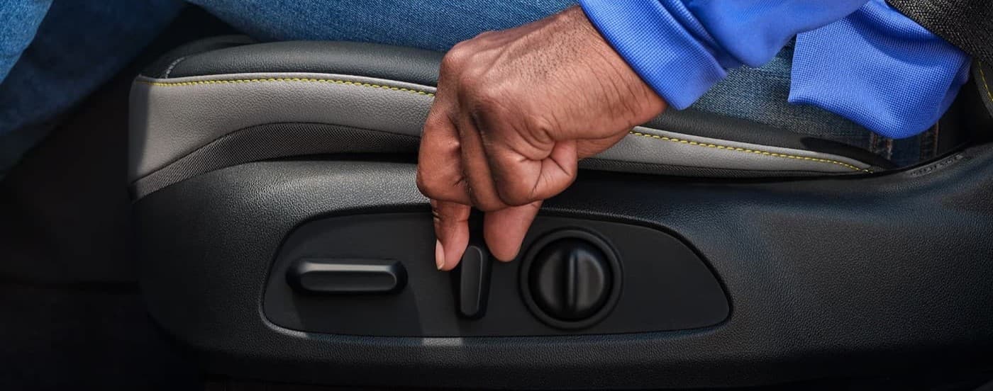 A person is shown using the seat adjuster knobs in a 2025 Chevy Trax for sale near Northhampton.